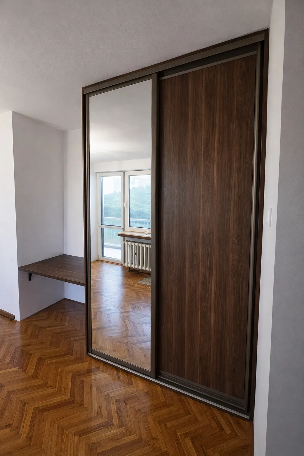 Szafa wnękowa na wymiar do przedpokoju z lustrem i drewnianymi drzwiami przesuwnymi, realizacja stolarza z Wrocławia